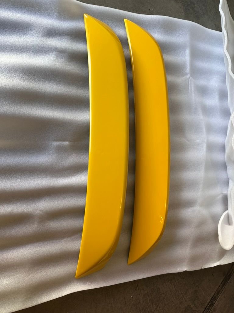 Left is OEM, right is eBay. The aftermarket spoiler has a deeper yellow. The OEM is some green undertones and is paler. 