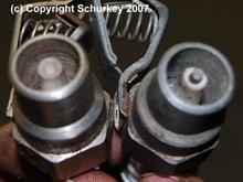 Recessed center electrode of HEI tester at left produces larger spark gap, vs. visible center electrode of ballast-resistor tester on right.