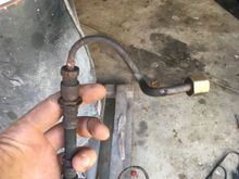 The line I'm looking for is above my index finger, it connects the soft line to the bracket where the front to rear brake line also connects to