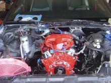 Replacement '95 3.4L engine w/the original 2.8L intake manifold, front timing cover. Also, the headers and chrome valve covers can be seen.