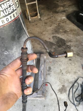 The line I'm looking for is above my index finger, it connects the soft line to the bracket where the front to rear brake line also connects to