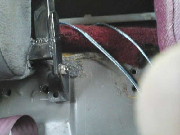Here is the hinge after moving it in 4 or 5 inches.The floor contours in right where the hinge bolts to the floor, so i made a 1/4" thick spacer and welded to the hinge. The spacer was wide enough that I was able to use th seatbelt hole to bolt it dowm.