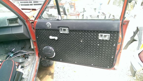 Neoprene (wetsuit material - same as wet okole seat covers) and 1/16" thick vinyl diamond tread lower (supposed to be for garage floors) - black handles and window crank on the way