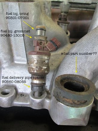 I know the injector doesn't go in that hole; this was for photo purposes.  Anyone know the part number for the injector "cup" to the right?  Mine are all dry-rotted and one of them was split.  Should I reuse the ones that are still in 1 piece and replace the o-rings inside them?