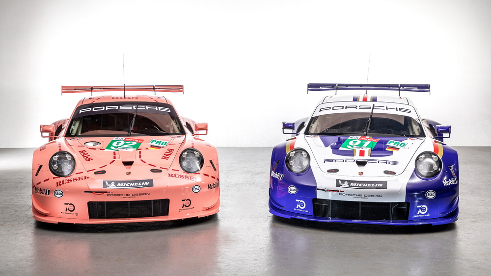 A pair of Porsche 911 RSR race cars in classic livery