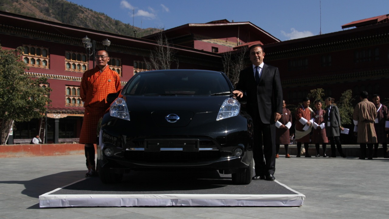 Tshering Tobgay, prime minister of Bhutan, with Nissan CEO Carlos Ghosn and Nissan Leaf electric car