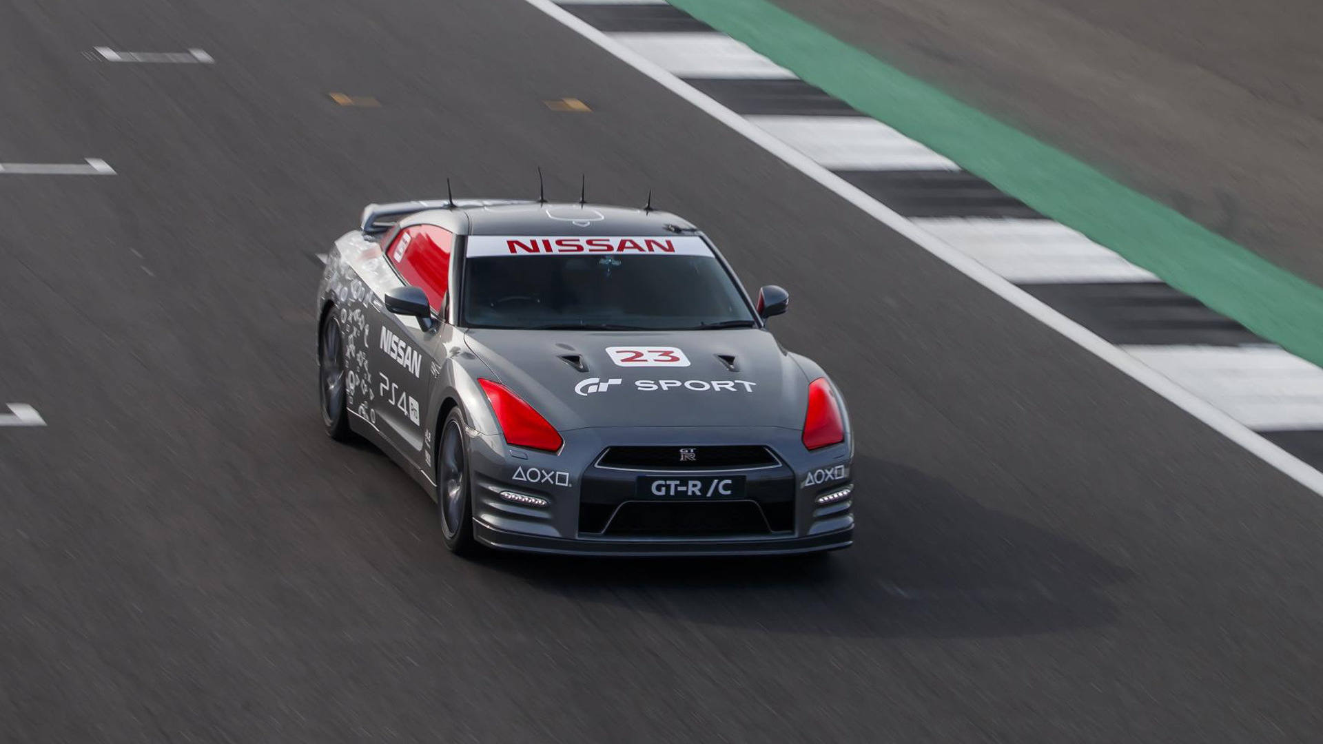 Jann Mardenborough drives a Nissan GT-R around a racetrack with a video game control