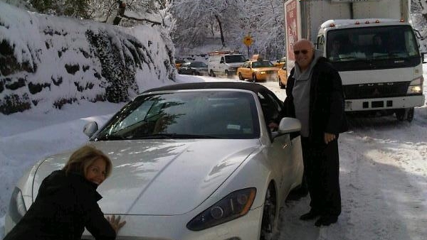 Katie Couric helps push Barry Diller's Maserati out of the snow