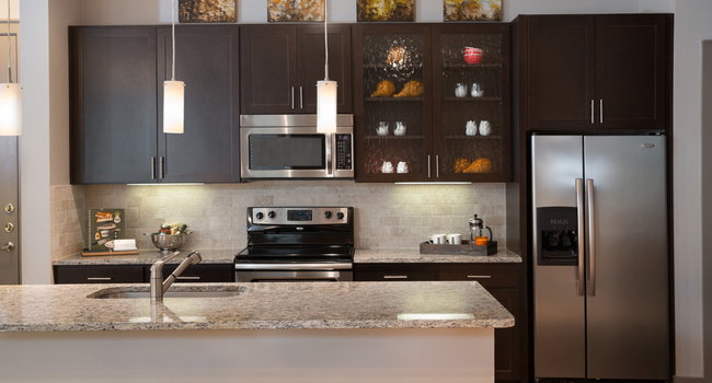 Gourmet kitchens feature granite or quartz countertops with natural stone backsplash